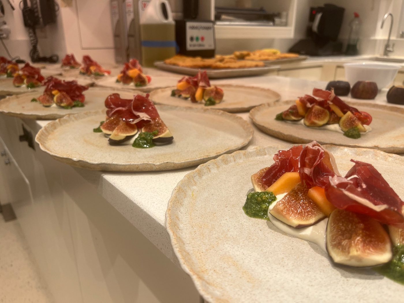 Fresh figs, jamón and melon with whipped cheese and pesto on handmade ceramic plates by chef Troy Davidson