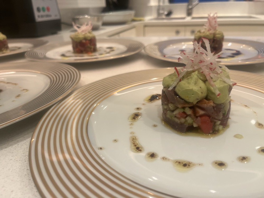 Tuna tartare with avocado mousse, shaved radish and herb oil on gold-banded china by superyacht chef Troy Davidson